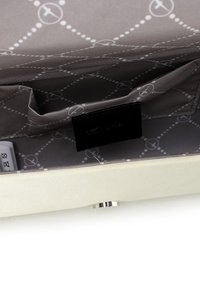 Beige satin clutch med grå foder, inklusive ett fack och en liten svart etikett, med ett prickigt mönster och metallspänne.