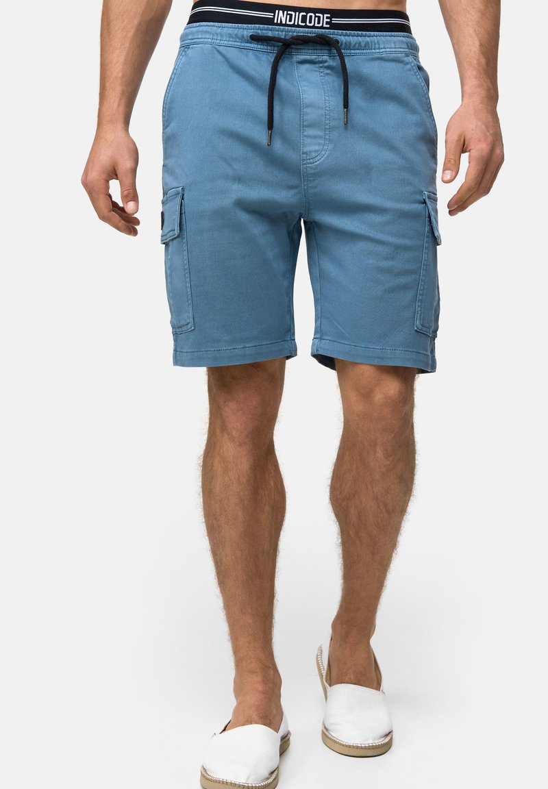 Shorts cargo en coton bleu avec cordon de serrage et deux poches latérales. Ceinture noire arborant le logo "INDICODE". Design décontracté et coupe droite.