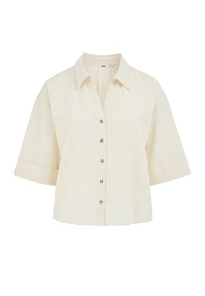 Gaiši bēša īss piedurkņu krekls ar pogām, smalkām vertikālām svītrām, punktētu apkakli un piecām brūnām pogām priekšpusē.