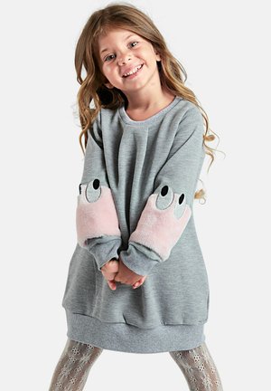 Graues Sweatshirtkleid mit pinken, flauschigen Ellenbogenpatches, die Augen zeigen. Weiches Material, lange Ärmel und abgerundeter Saum. Gemusterte Leggings darunter.