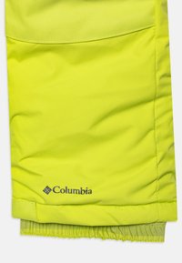 Giacca Columbia di un brillante giallo, con tessuto testurizzato, polsini elastici e un logo nell'angolo in basso a destra.