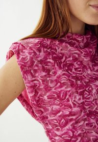Ružový flitrový top s textúrovaným kvetinovým vzorom, s krátkymi, štruktúrovanými rukávmi a vysokým výstrihom pre moderný siluetu.