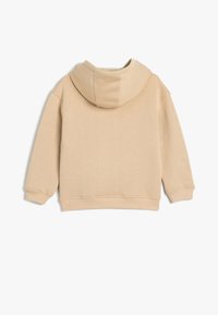 Sudadera beige con una textura suave, capucha ajustable con cordón y puños acanalados. Diseño simple y minimalista sin logotipos visibles.