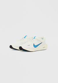 Fehér sportcipők sima felülettel, kék Nike logóval, kék díszítésekkel és fekete gumitalppal.