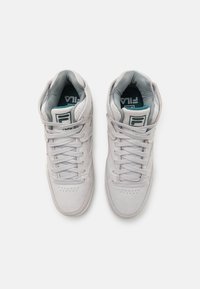 Sneakers grigi alti con finitura in suede, dotati di pannelli in rete, perforazioni e un logo sulla linguetta. I lacci sono di un grigio chiaro.
