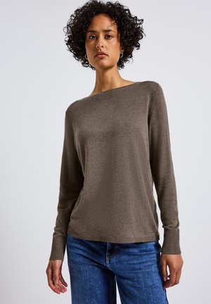 Brauner Pullover mit langen Ärmeln und Bootsausschnitt, aus weichem Stoff; kombiniert mit blauen Jeans und mit gerippten Bündchen und Saum.
