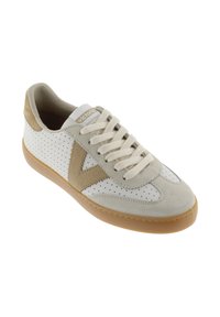Zapatilla de ante blanca y beige con laterales perforados, diseño en "V" color beige, cordones beige y suela de goma color caramelo.