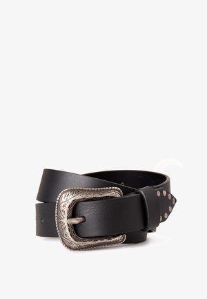 Ceinture en cuir noire avec boucle en argent gravée et clous argentés sur la pointe effilée, enroulée sur un fond blanc.