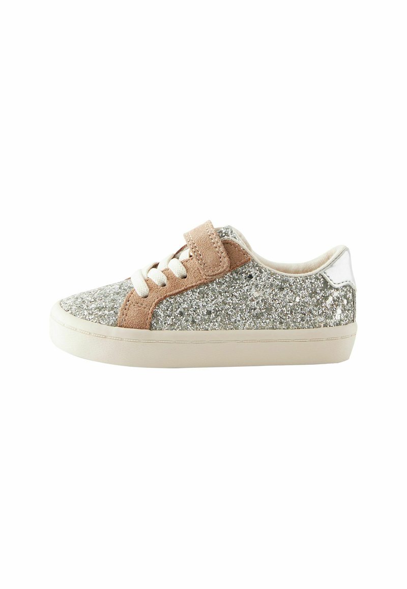 Baskets recouvertes de paillettes argentées avec des accents en suede beige, lacets blancs et semelle beige. Comprend une sangle en velcro et un détail en cuir lisse au niveau du talon.