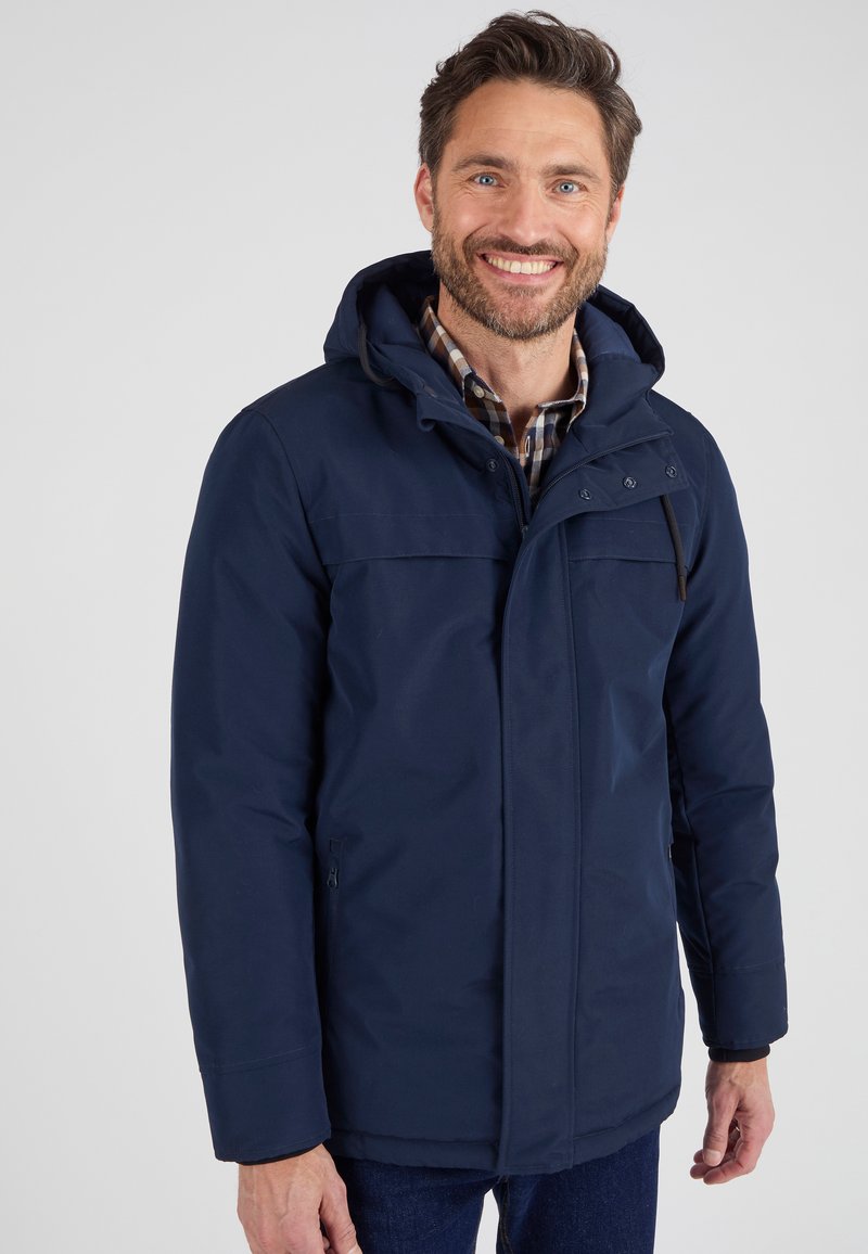 Giacca impermeabile blu navy con cappuccio, zip frontale e tasche sul petto. Presenta una texture liscia e un cordino regolabile.