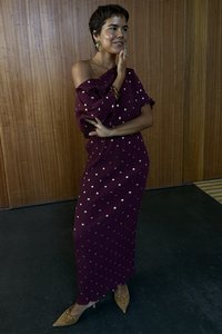 Bordó bordázott ruha vállvillantós nyakkivágással, apró arany pöttyökkel díszítve. Párosítva hegyes orrú, szegecses bézs cipőkkel.