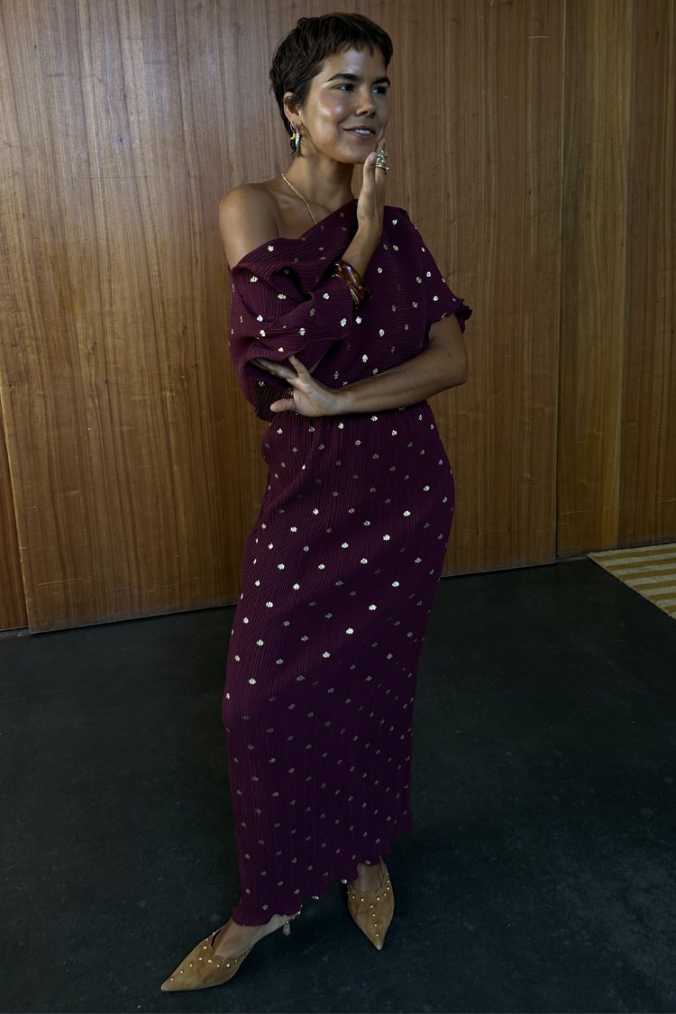 Bordó bordázott ruha vállvillantós nyakkivágással, apró arany pöttyökkel díszítve. Párosítva hegyes orrú, szegecses bézs cipőkkel.