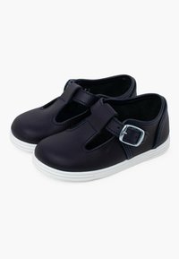 Scarpe in pelle navy con suola in gomma bianca, caratterizzate da una fascetta con fibbia e un design intagliato, punta arrotondata e texture liscia.