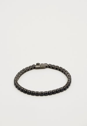 Armbånd med sammenkoblede sorte sten sat i en mørk metal kæde med en bokslås, præsenteret på en neutral lys baggrund.