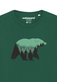 Groene katoenen T-shirt met een grafisch ontwerp van een beer gevuld met bomen. Heeft een ronde halslijn en korte mouwen met een gladde textuur.