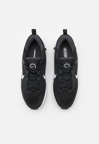 Czarne buty sportowe z siateczkową cholewką, okrągłym noskiem i wzmocnionym piętą. Białe akcenty i sznurowadła. Amortyzujące podeszwy dla komfortu. Minimalistyczny design.