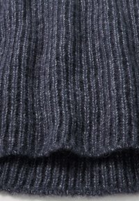 Dunkelgrauer, gerippter Wollstrickstoff, der die detaillierte Textur und die gefaltete Kante zeigt und die weichen, flauschigen Garnfasern hervorhebt.