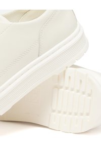 Sneaker in pelle bianca con una superficie liscia, dotata di una suola in gomma spessa, dettagli di cucitura discreti e una suola con motivo per una migliore aderenza.