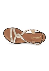 Sandalia de mujer dorada y tono beige con correas entrecruzadas, detalles de tela, suela plana, correa ajustable en el tobillo y logotipo de la marca en relieve.