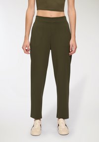 Pantaloni verde oliva con design a gamba dritta, caratterizzati da una vita alta e senza tasche visibili. Le gambe hanno una texture liscia e una finitura pulita.