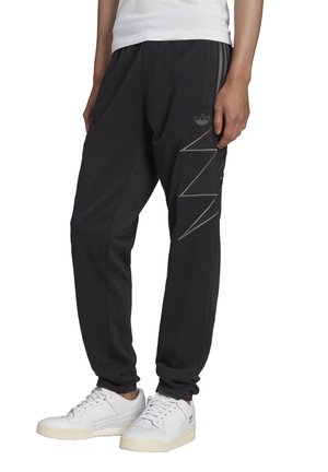 Pantalones deportivos negros con puños elásticos, dos bolsillos laterales y un diseño en zigzag tonal en la pierna izquierda. Hechos de una tela suave y flexible.