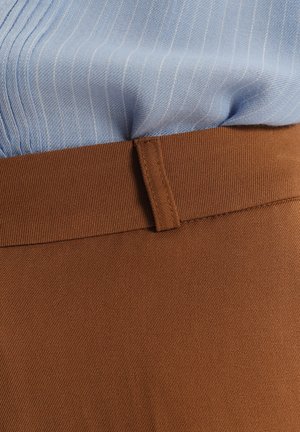 Brązowy pasek z tkaniny o gładkiej fakturze, w połączeniu z jasnoniebieską koszulą w paski o miękkim splotcie. Skupienie na szczegółach pasa.
