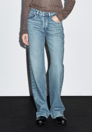 Lyseblå jeans med lige ben og høj talje, fem-lommer design og knaplukning. Færdiggjort med sidesøm detaljer.