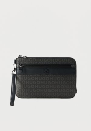 Zwarte en grijze Hugo polstasje met geperst logopatroon, voorvak met rits en afneembare polsband op een witte achtergrond.