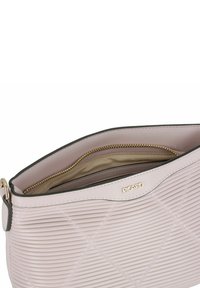 Rosa strukturierte Lederhandtasche mit einem Reißverschluss-Innenfach, ausgestattet mit einem goldfarbenen Logo und diagonalem Rippmuster.