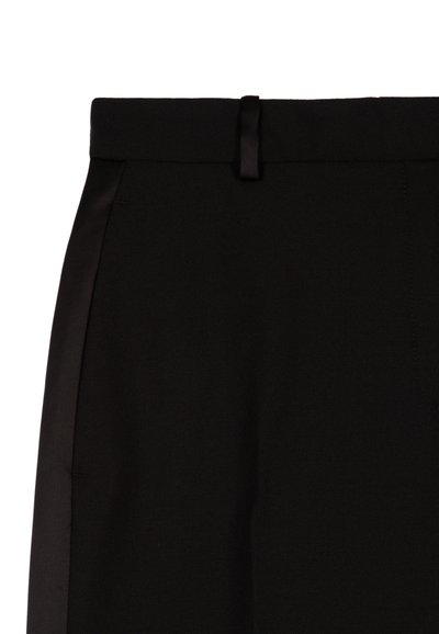 Zwarte broeken hebben een gladde stof met een slim fit, een platte voorkant, zijzakken en een strakke tailleband die wordt benadrukt door een lus.