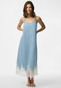 Gai zilgans džinsi kleita ar plānām siksnām, V veida kakla izgriezumu un baltiem mežģīņu apmalēm ap apakšu. Gluda tekstūra, līdz ceļgaliem, ikdienas piegriezums.