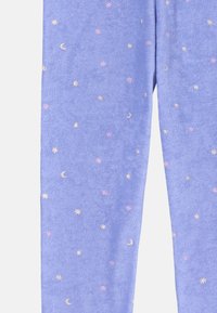 Purple fleece leggings featuring a scattered pattern of small moons and stars in pink and gold. Soft texture with a comfortable fit.