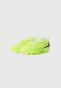 Neon gule fotballsko med svarte og oransje Nike-swooshlogoer, teksturert overdel og formede knotter på hvit bakgrunn.