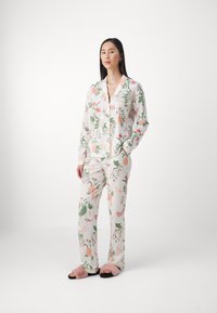 Floral pajama set in soft fabric; features long sleeves, button-up top, and elastic waist pants. Colors include white, pink, green, and orange.
