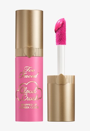 Too Faced Cloud Crush Whipped Lip & Cheek Farbe in einer pinken Tube mit goldenen Akzenten. Der Applikator mit Spatel hat eine flauschige Spitze für eine einfache Anwendung.