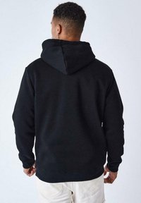Sudadera negra con capucha y mangas largas, hecha de una tela suave. Presenta un bolsillo tipo canguro, puños y dobladillo ribeteados.