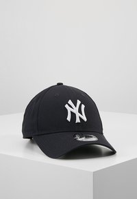 Black baseball cap with a white embroidered "NY" logo on the front, structured design, curved brim, and a shiny, plastic adjuster on the back.