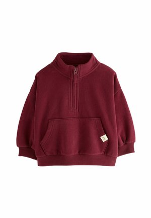Burgunderfarbener Fleece-Pullover mit halbem Reißverschluss, gerippten Bündchen, Fronttasche und einem kleinen Etikett. Weicher Stoff und lockere Passform. Ideal für legere Anlässe.