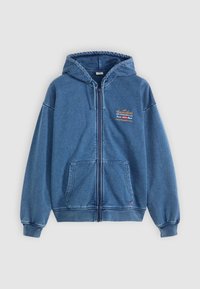 Blå hettegenser med glidelås laget av myk denim, med to frontlommer, hette og en liten brodert logodetalj på brystet.