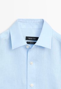Light blue linen dress shirt with spread collar, white buttons, and a black label reading "Massimo Dutti" inside the collar.