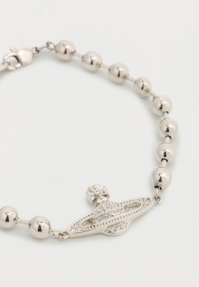 Ασημένιο βραχιόλι με χάντρες με ένα γοητευτικό στοιχείο σε σχήμα πλανήτη διακοσμημένο με στρας, που φέρει έναν σταυρό στην κορυφή, σε λευκό φόντο.