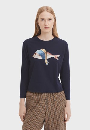 Navy long-sleeve shirt featuring a fish graphic with a blue and yellow headband. Soft fabric and relaxed fit, paired with checkered pants.
