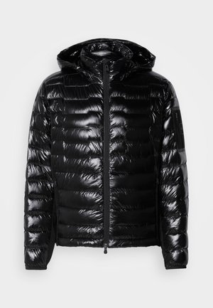 Svart puffer-jacka med glansig yta, dragkedja fram, huva och kviltad textur. Har sidfickor och ett litet emblem på ärmen.