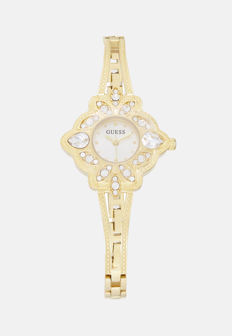 Gold-tone watch with floral design, round face, and crystal accents. Features a textured band and minimalist dial. Brand name visible.