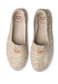 Scarpe slip-on beige intrecciate realizzate in un materiale simile alla paglia, con una morbida fodera in tessuto e un piccolo dettaglio in pelle marrone chiaro nella parte anteriore.