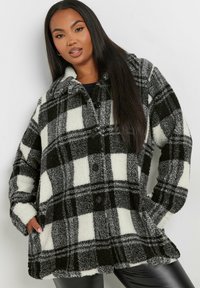 Svart- och vitrutigt fleecejacka med krage, framknäppning och lös passform. Mjuk textur och varm utseende är anmärkningsvärt.