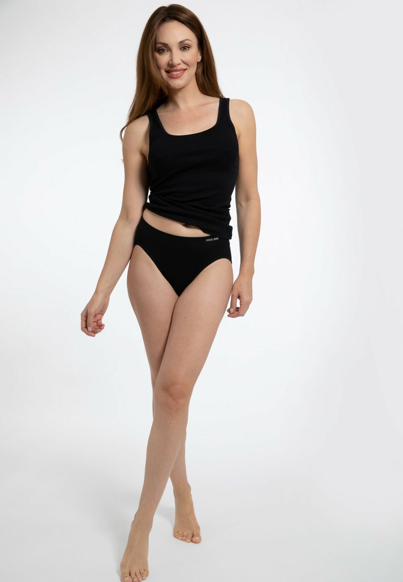 Top in cotone rigato nero e lingerie coordinata in stile bikini. Il tessuto appare morbido con un design aderente. Nessun motivo o accentuazione visibile.