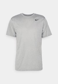 Grå lätt kortärmad T-shirt tillverkad av slät tyg. Har en rund hals och en liten svart Nike-logga på den övre vänstra sidan.