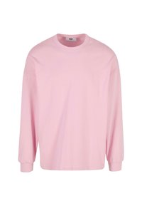 Lichtroze lange mouwen T-shirt van katoen. Heeft een ronde halslijn en een losse pasvorm. Geen zichtbare patronen of hardware details.