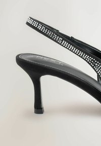 Melni augstpapēžu sandales ar gludu, teksturētu virsmu, kurām ir rhinestone akcentēta siksniņa un glīta, eleganta silueta.